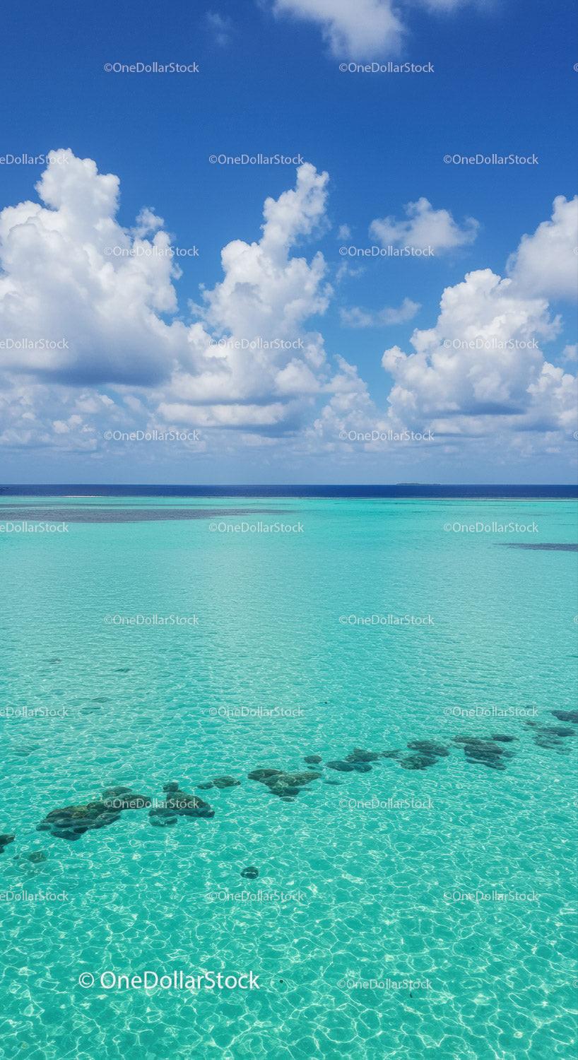 Bright Blue Sky Over Turquoise Ocean with Fluffy White Clouds