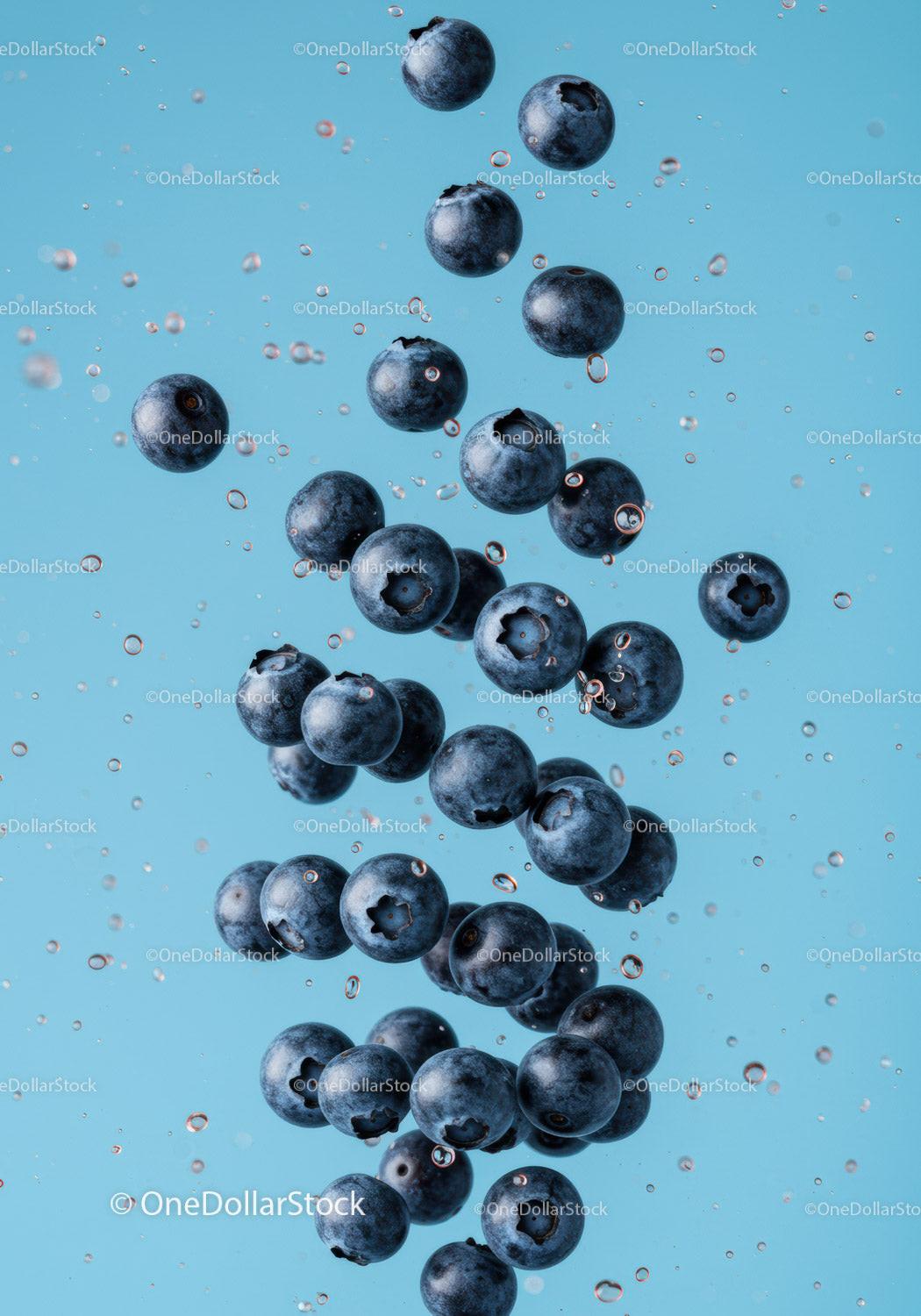 Fresh blueberries suspended in clear water splash