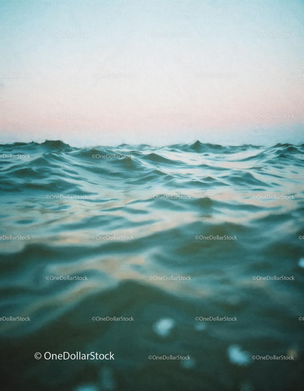 Calm Ocean Waves Over Deep Blue Water with Sunset Sky