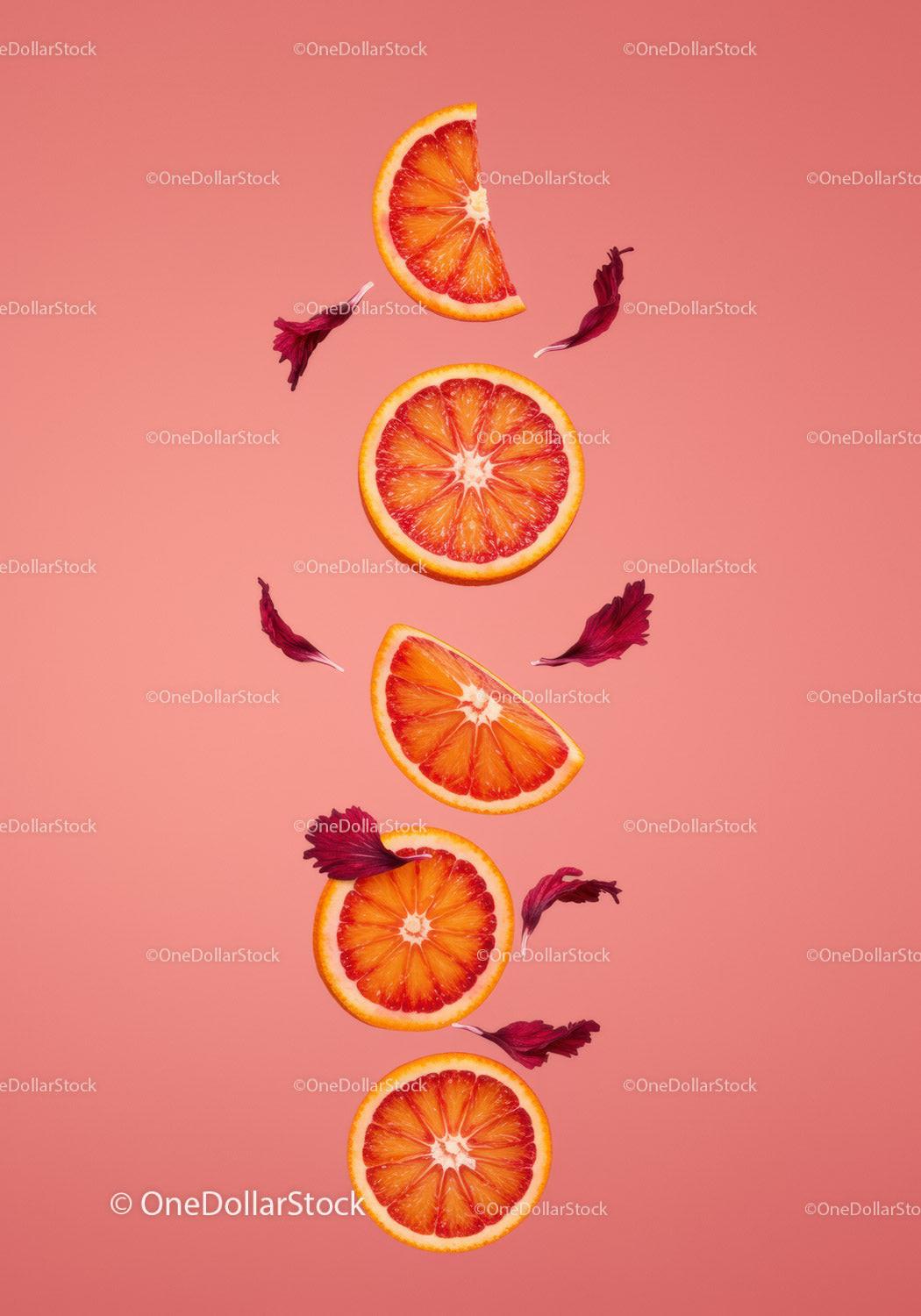 Blood Orange Slices with Hibiscus Petals on Pink Background