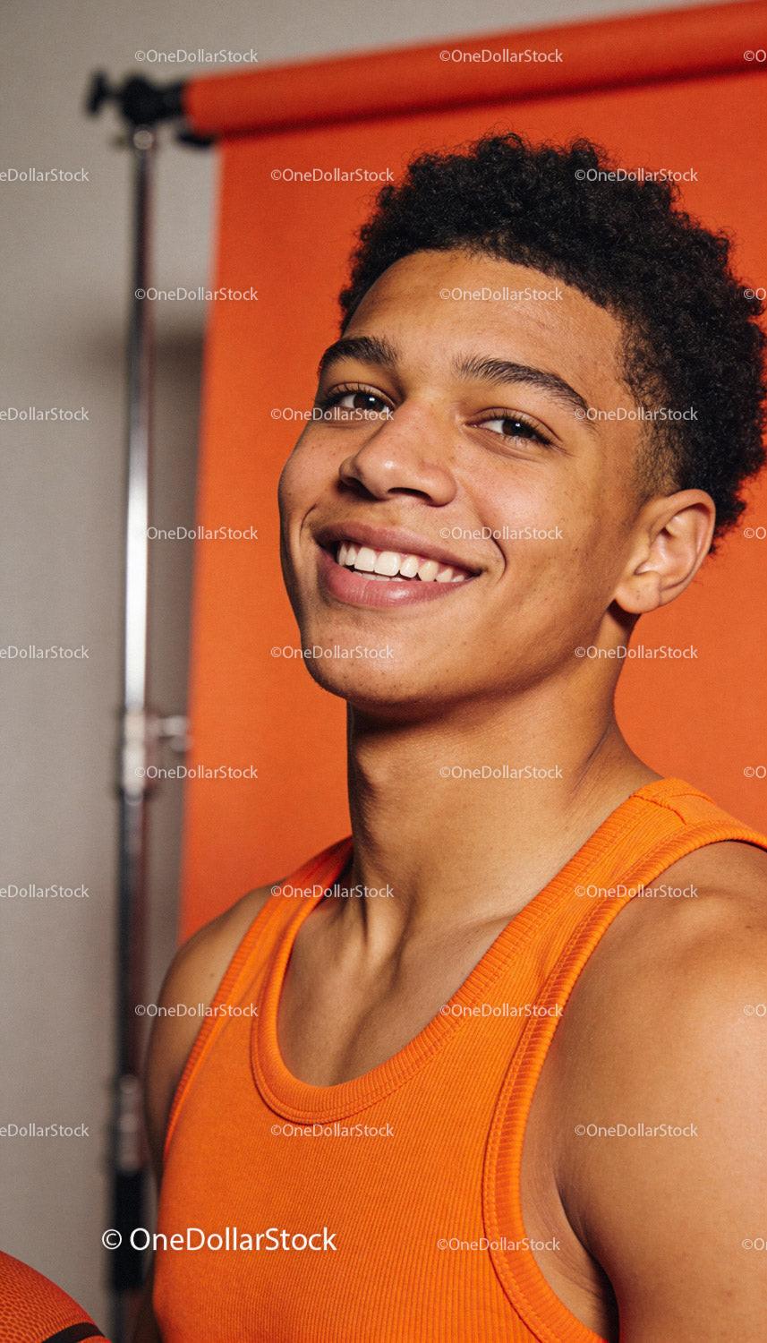 Confident young athlete smiling in bright orange top