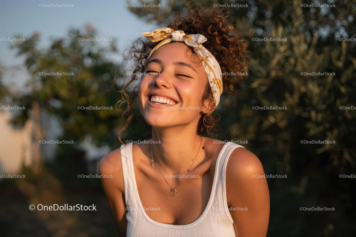 Portrait of a Smiling Young Woman with Curly Hair and Headband Outdoors