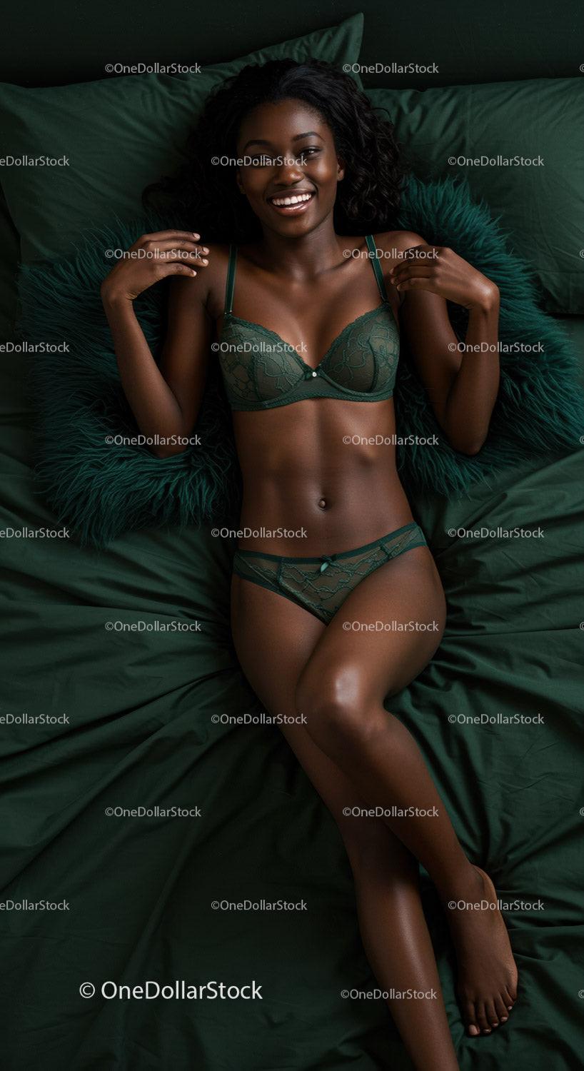 Smiling woman relaxing on dark green bedding in lingerie