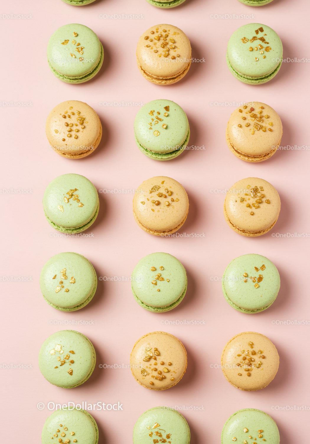 Rows of elegant green and beige macarons on pink background