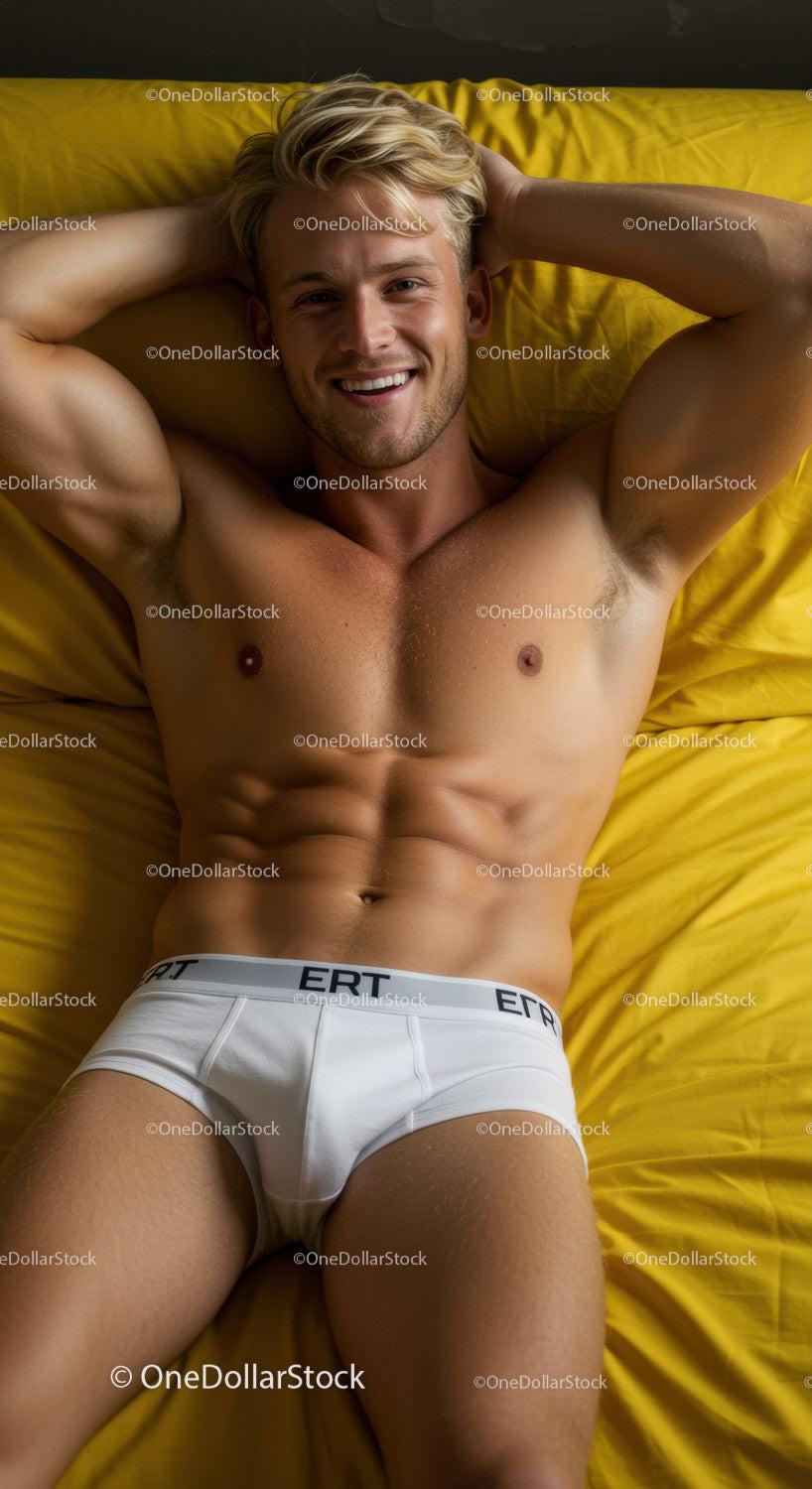 Smiling shirtless man relaxing on yellow bed