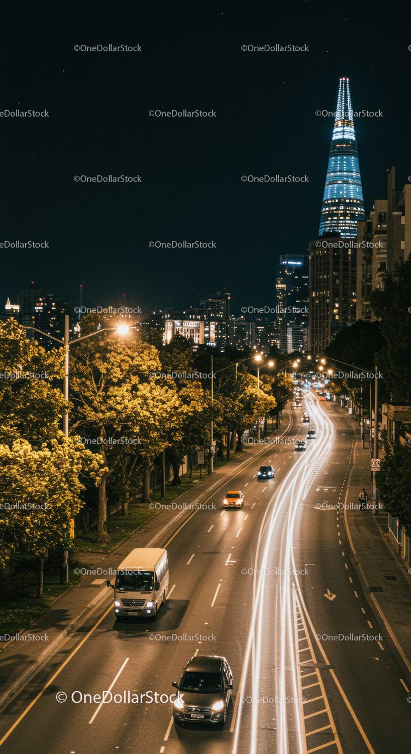 Night Cityscape with Illuminated Skyscraper and Moving Traffic in Downtown