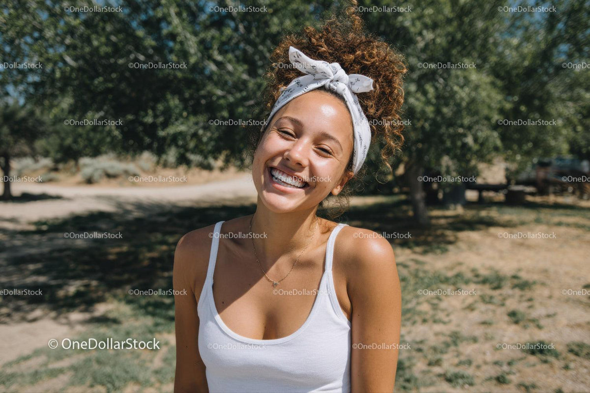 Joyful Woman Smiling Outdoors in Sunlit Park