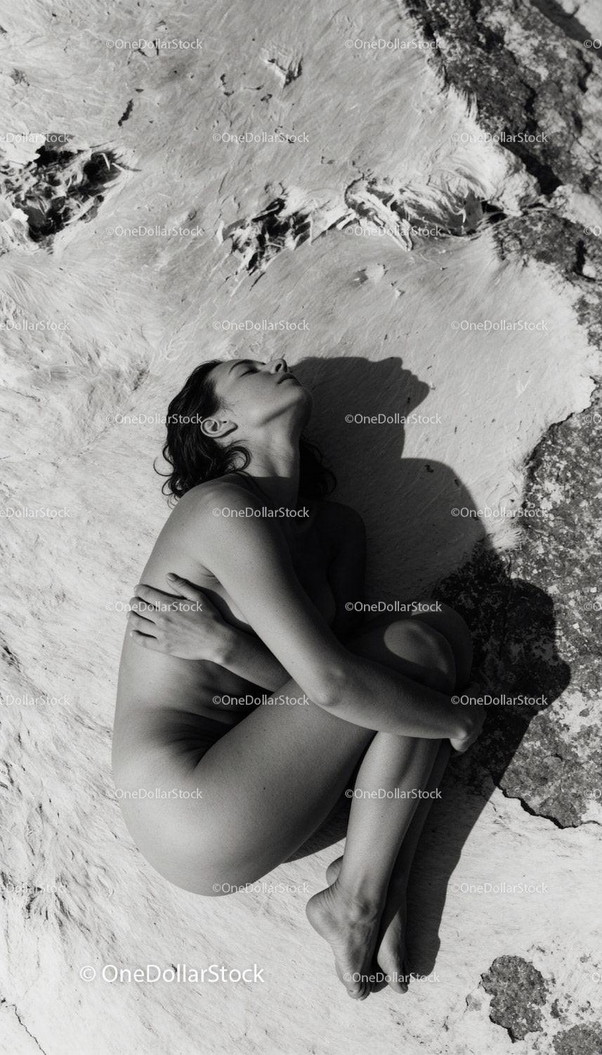 Serene woman embracing herself lying on natural surface