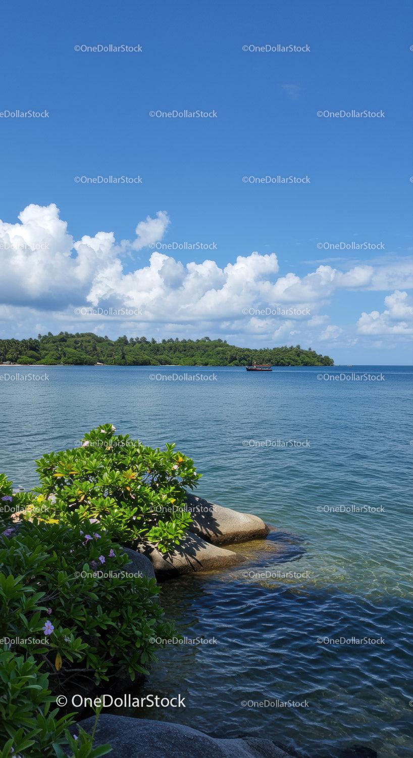 Majestic Tropical Island with Blue Ocean and Green Foliage Under Cloudy Sky