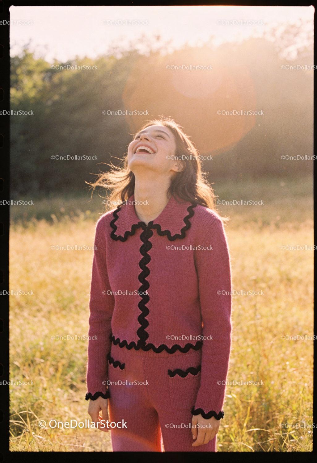 Joyful young woman laughing outdoors in warm sunlight