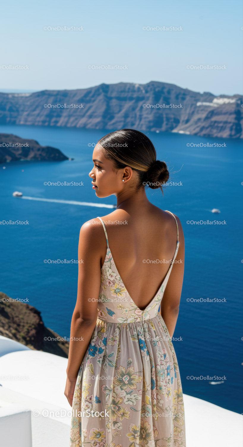 Young woman in floral dress overlooking blue sea and cliffs