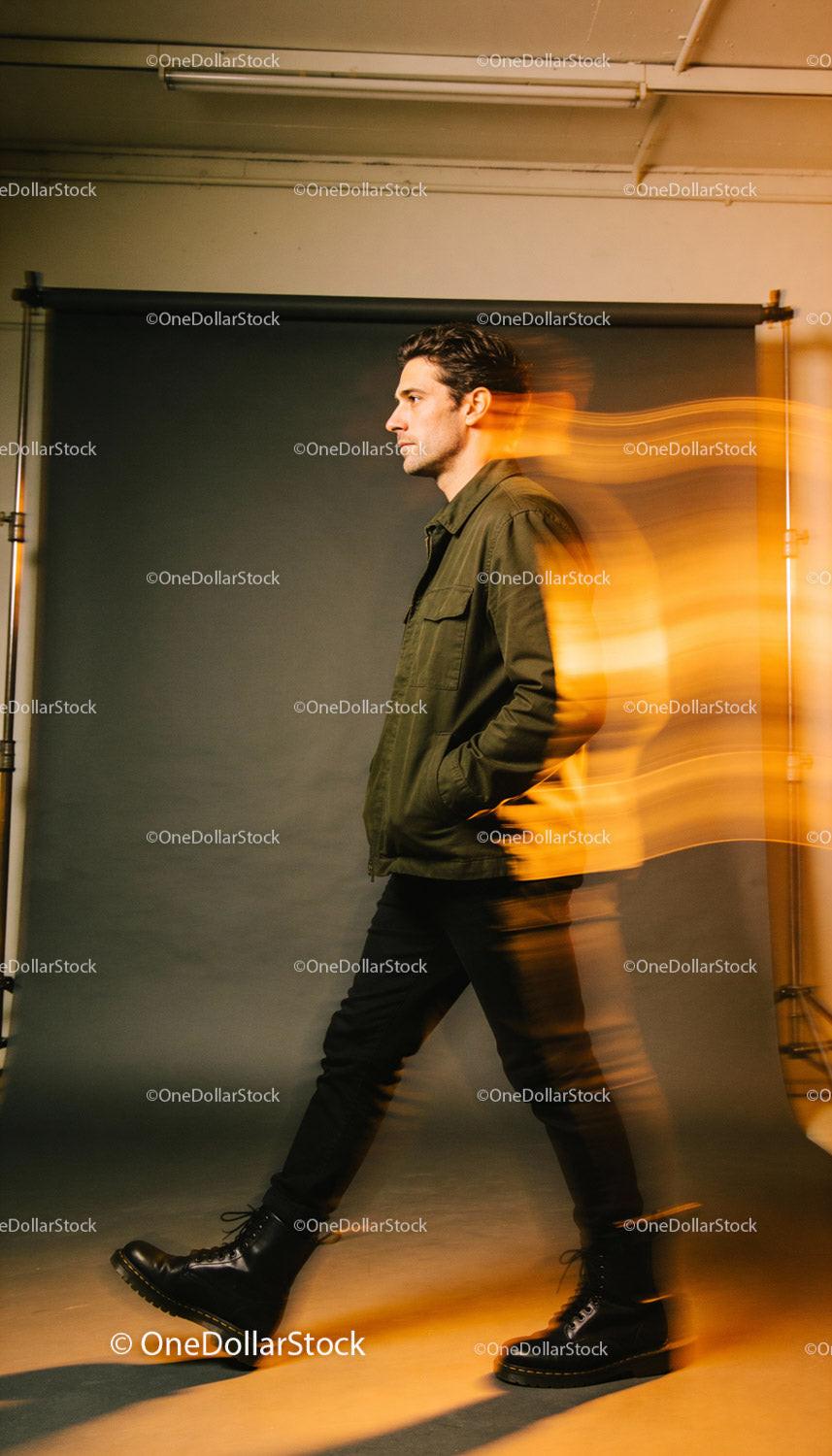 Man walking confidently in olive jacket and black boots