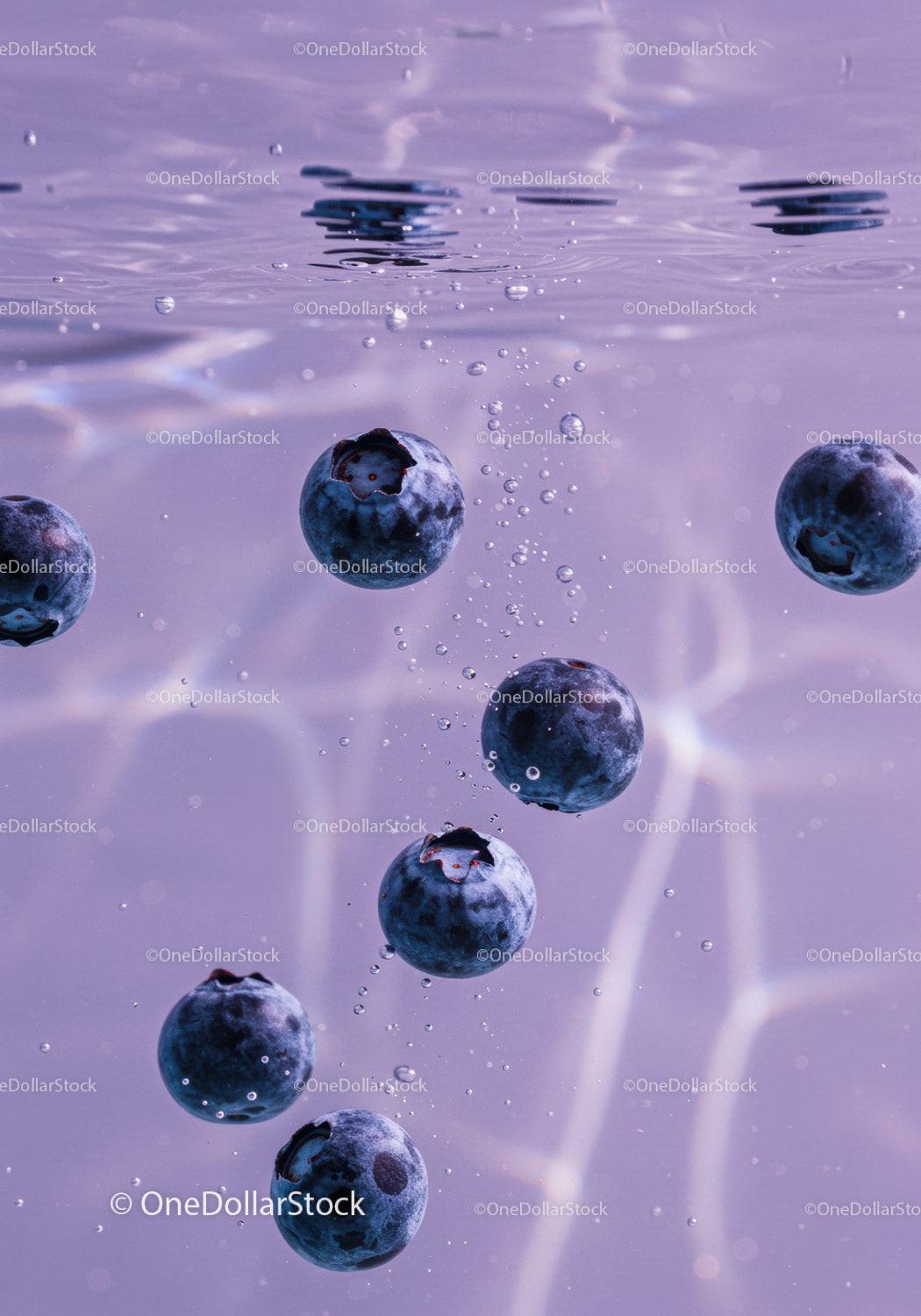 Fresh blueberries sinking in clear water with bubbles