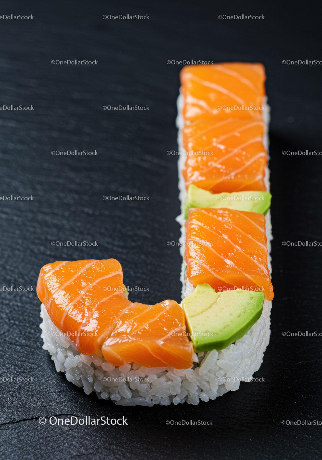 Fresh salmon and avocado sushi roll on dark surface