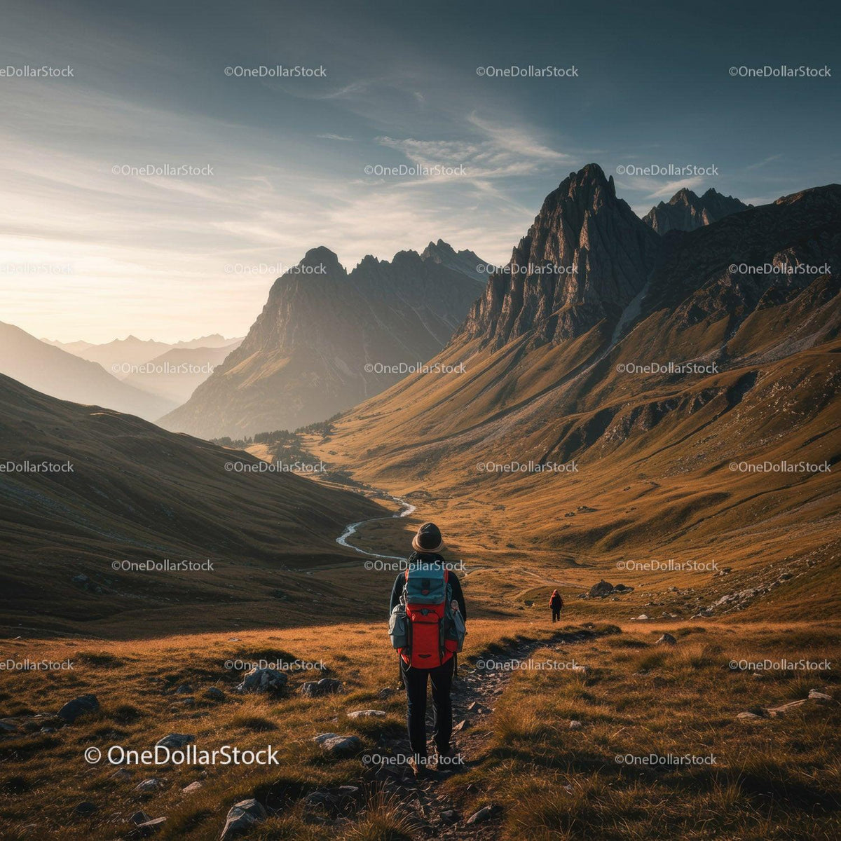 Hiker Exploring Mountain Valley with Rocky Peaks Under Sunset Sky