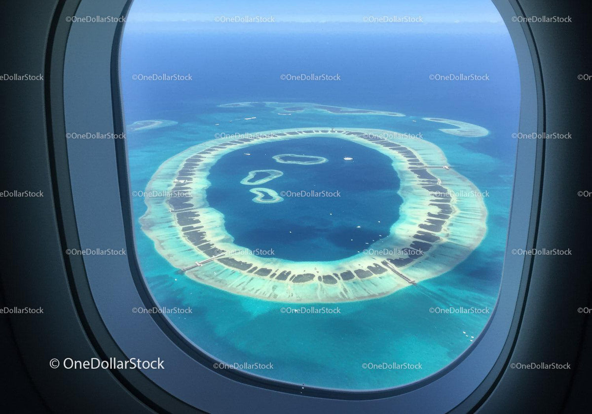 Aerial View of Overwater Bungalows on Tropical Island with Blue Ocean