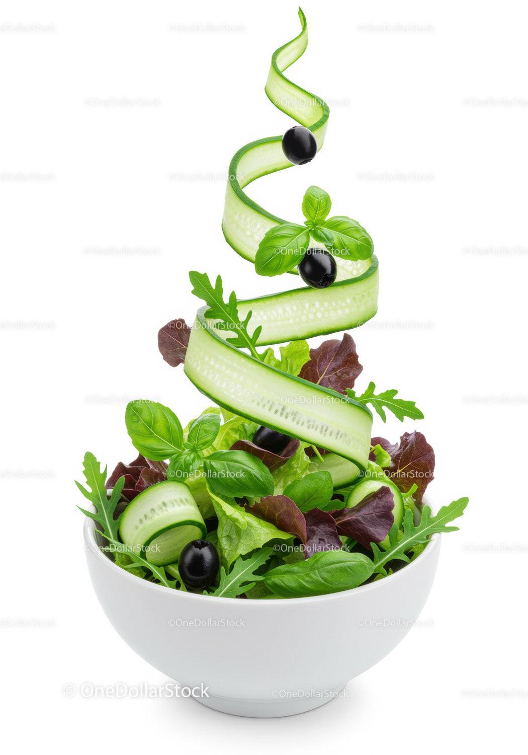 Fresh green salad with cucumber ribbons and black olives