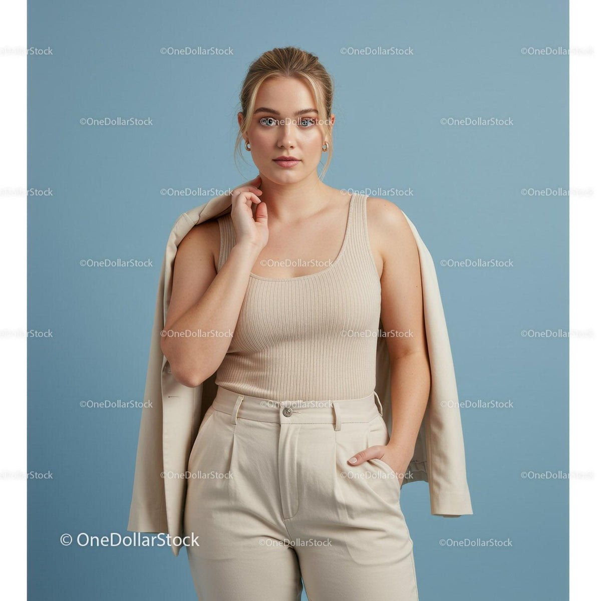 Elegant woman in beige tank top and stylish beige trousers posing confidently