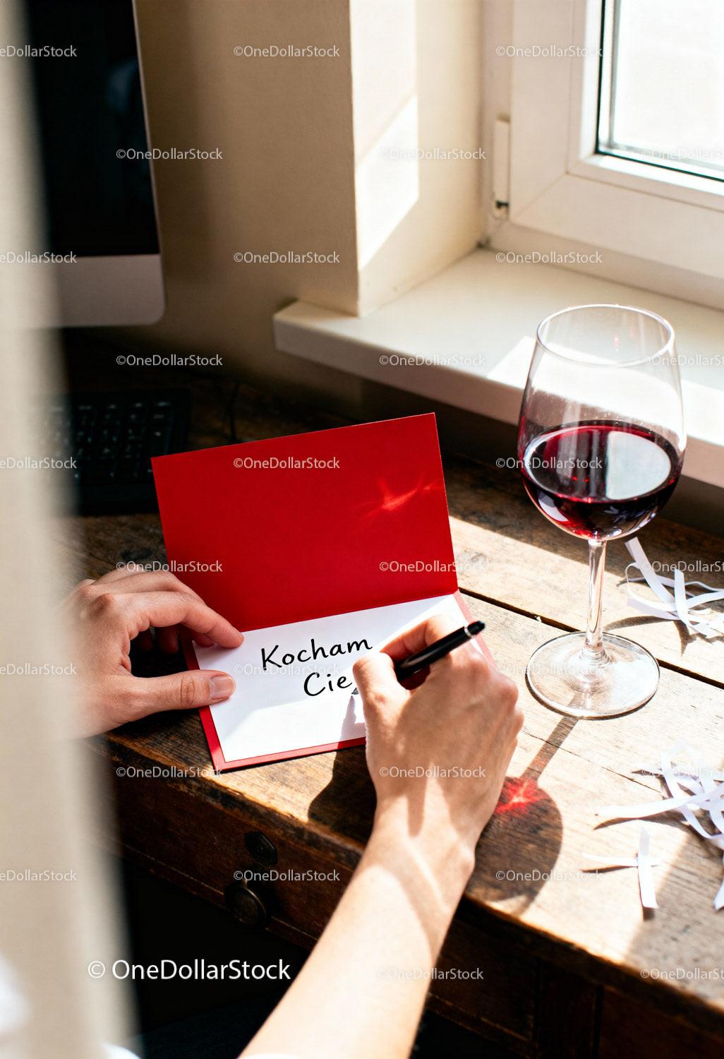 Writing a heartfelt love note with red wine by the window