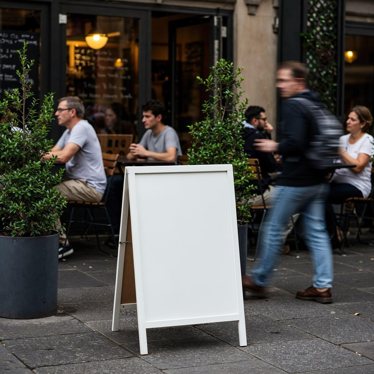 Blank white board at bustling outdoor cafe seating area JPG Mockup Image preview
