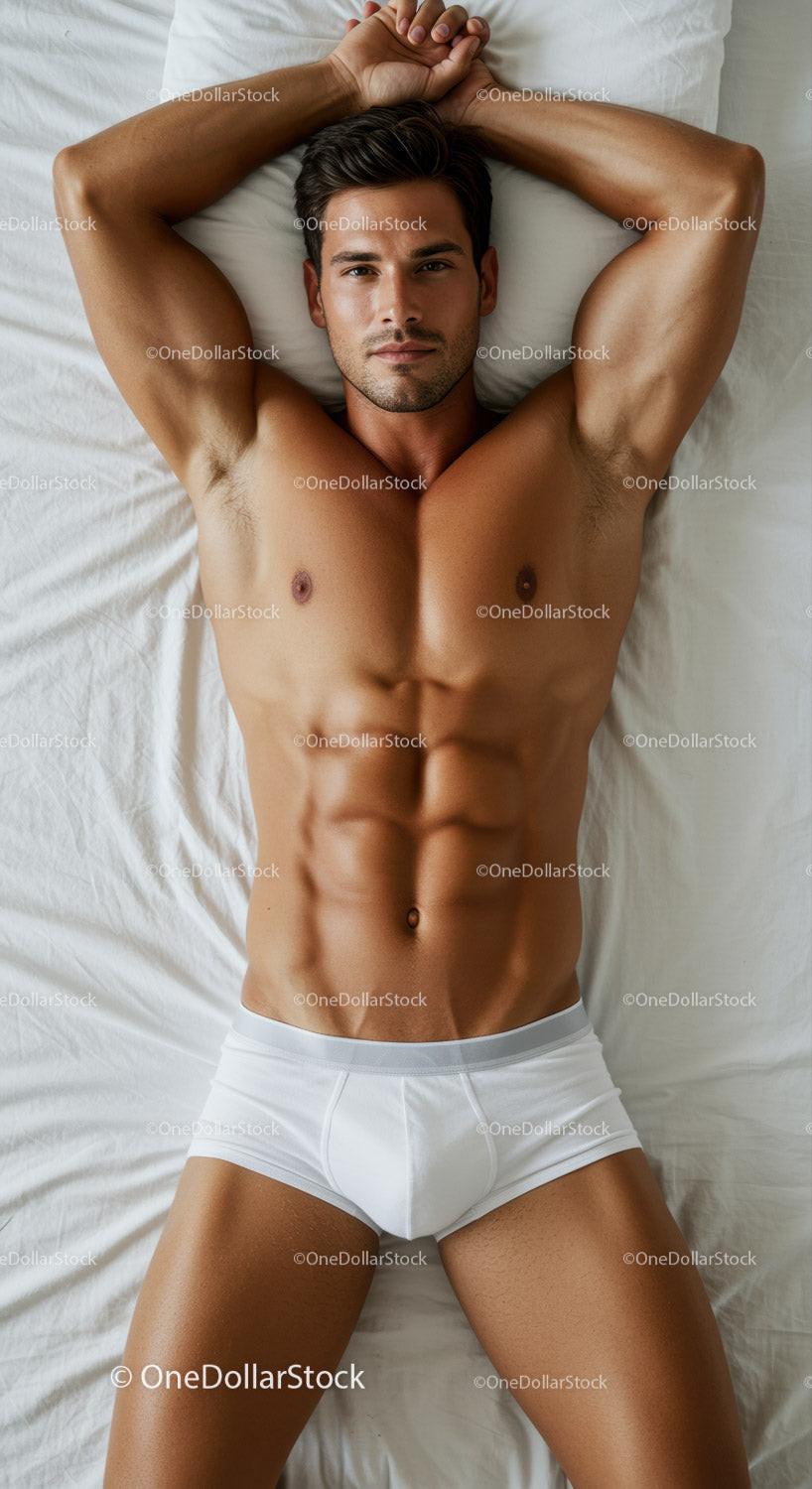 Fit muscular man relaxing on white bed in underwear