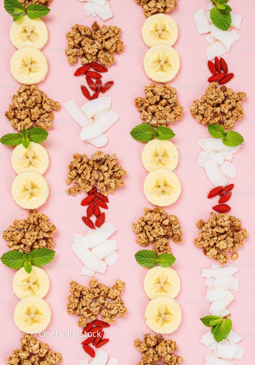 Healthy breakfast ingredients laid out on soft pink background