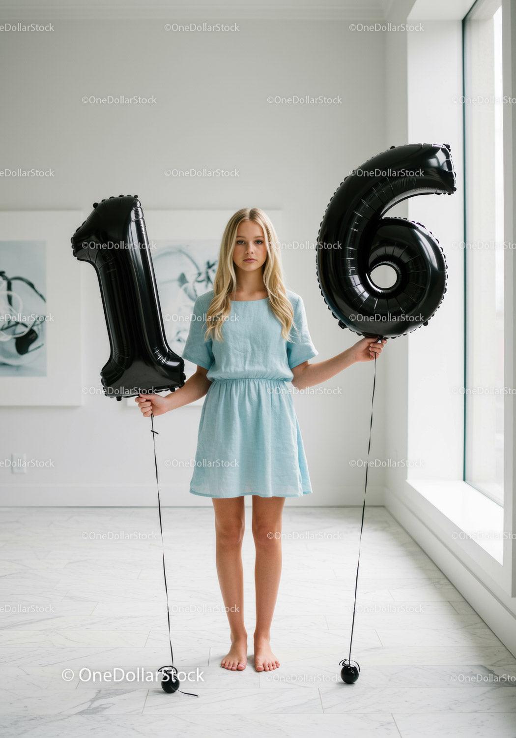 Teenage girl holding black balloons shaped as number sixteen