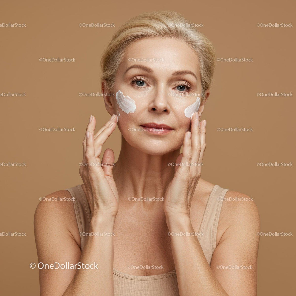 Elegant Mature Woman Applying Facial Moisturizer for Youthful Skin