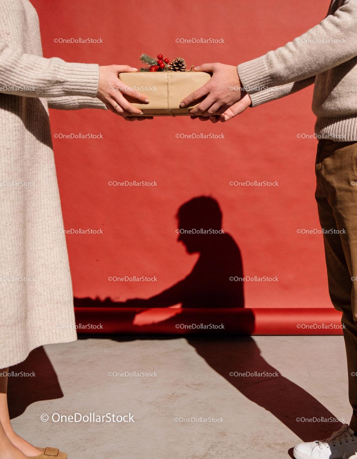 Hands Exchanging Christmas Gift with Festive Decorations
