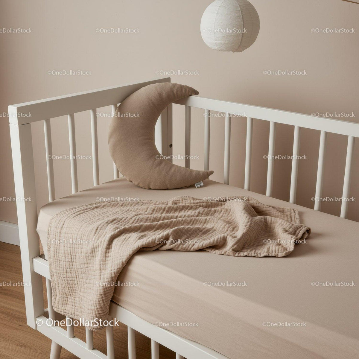 Cozy beige baby crib with crescent pillow and blanket