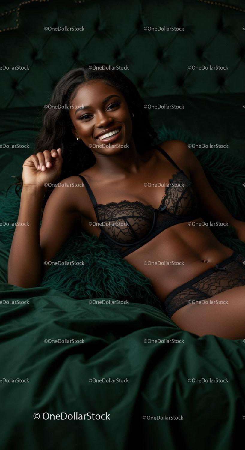 Smiling woman in elegant black lace lingerie relaxing on bed