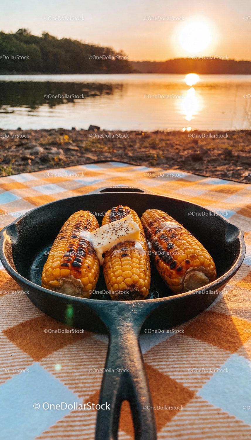 Grilled corn on the cob with butter at sunset picnic