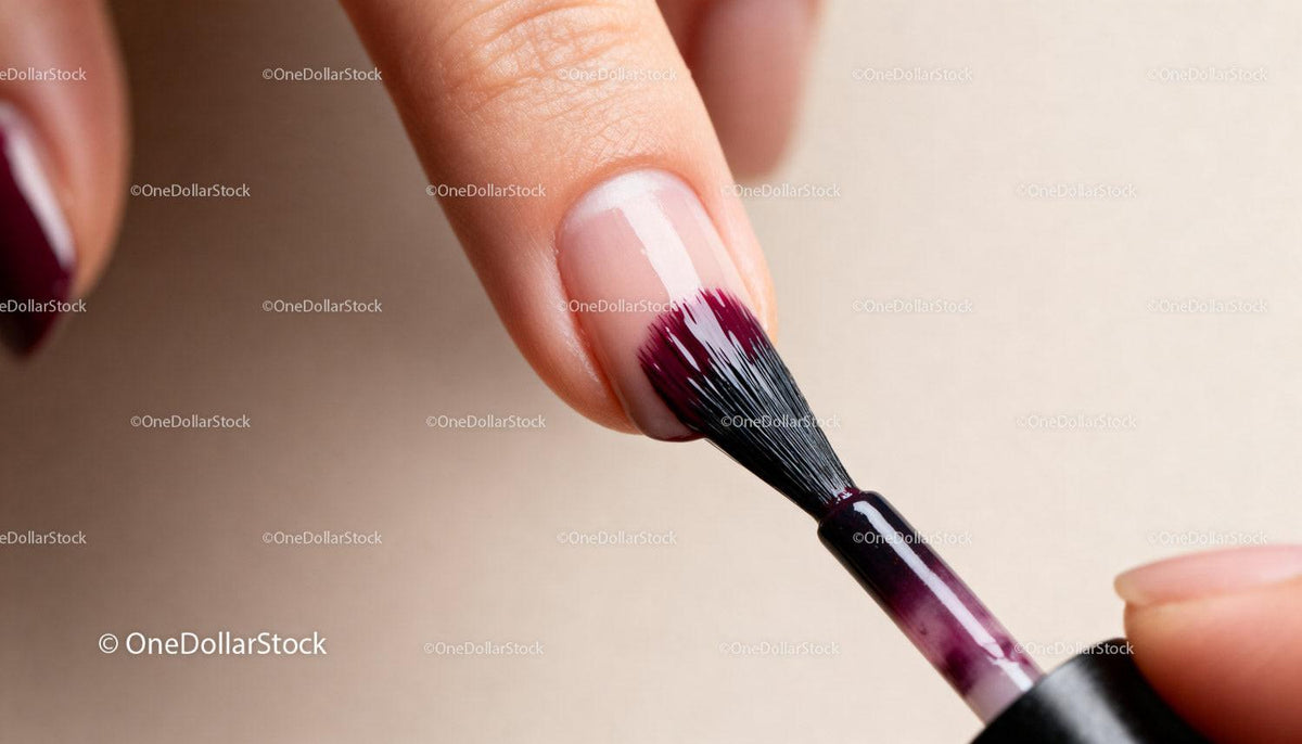 Close-up of applying dark nail polish on fingernail