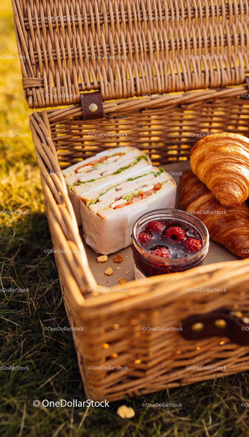 Fresh picnic basket with sandwiches croissants and jam