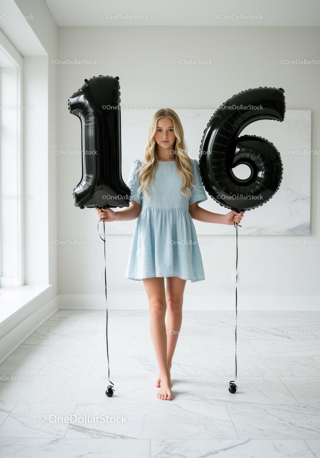 Teenage girl holding black 16 number balloons indoors