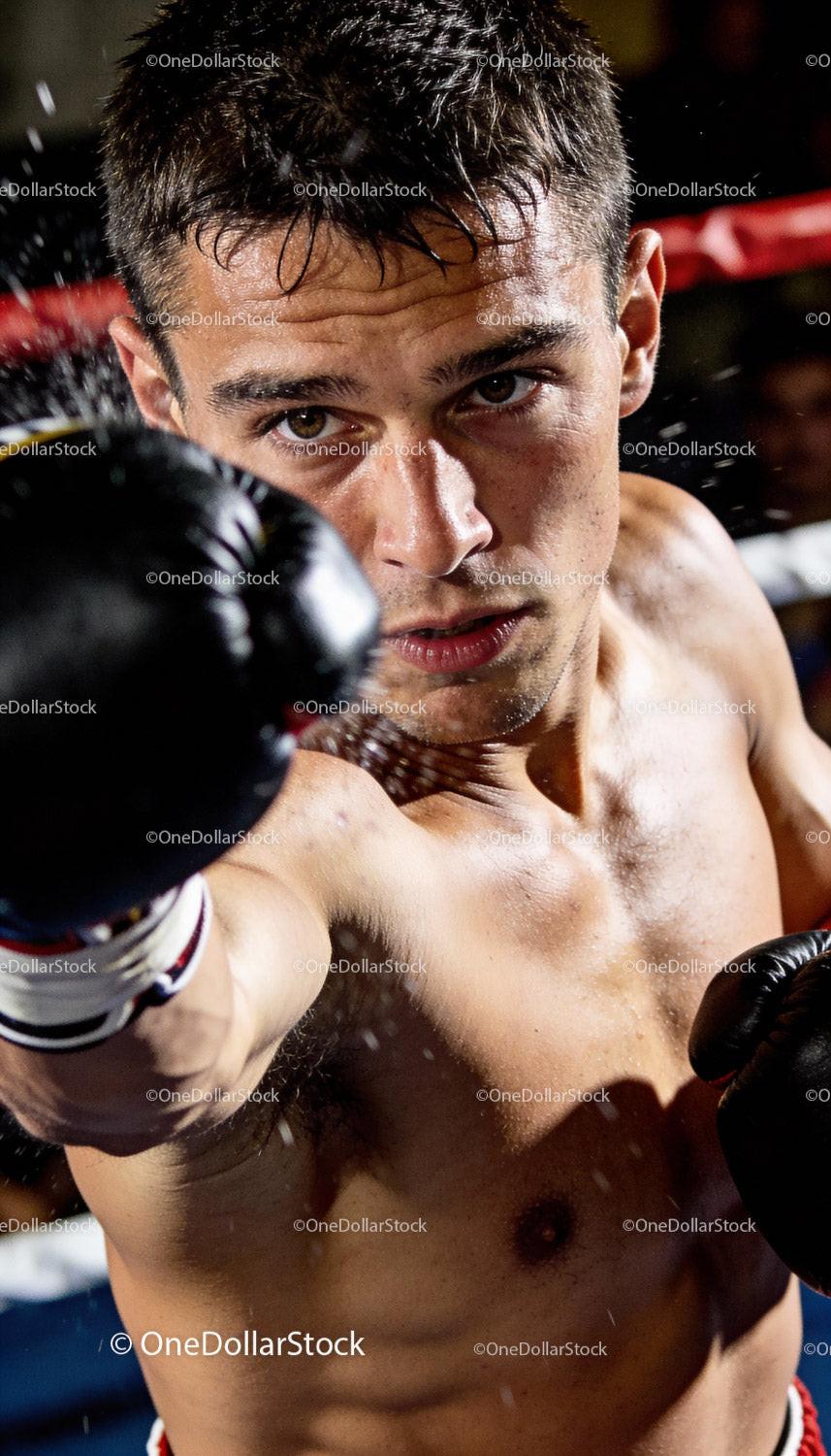 Focused male boxer delivering a powerful punch in ring