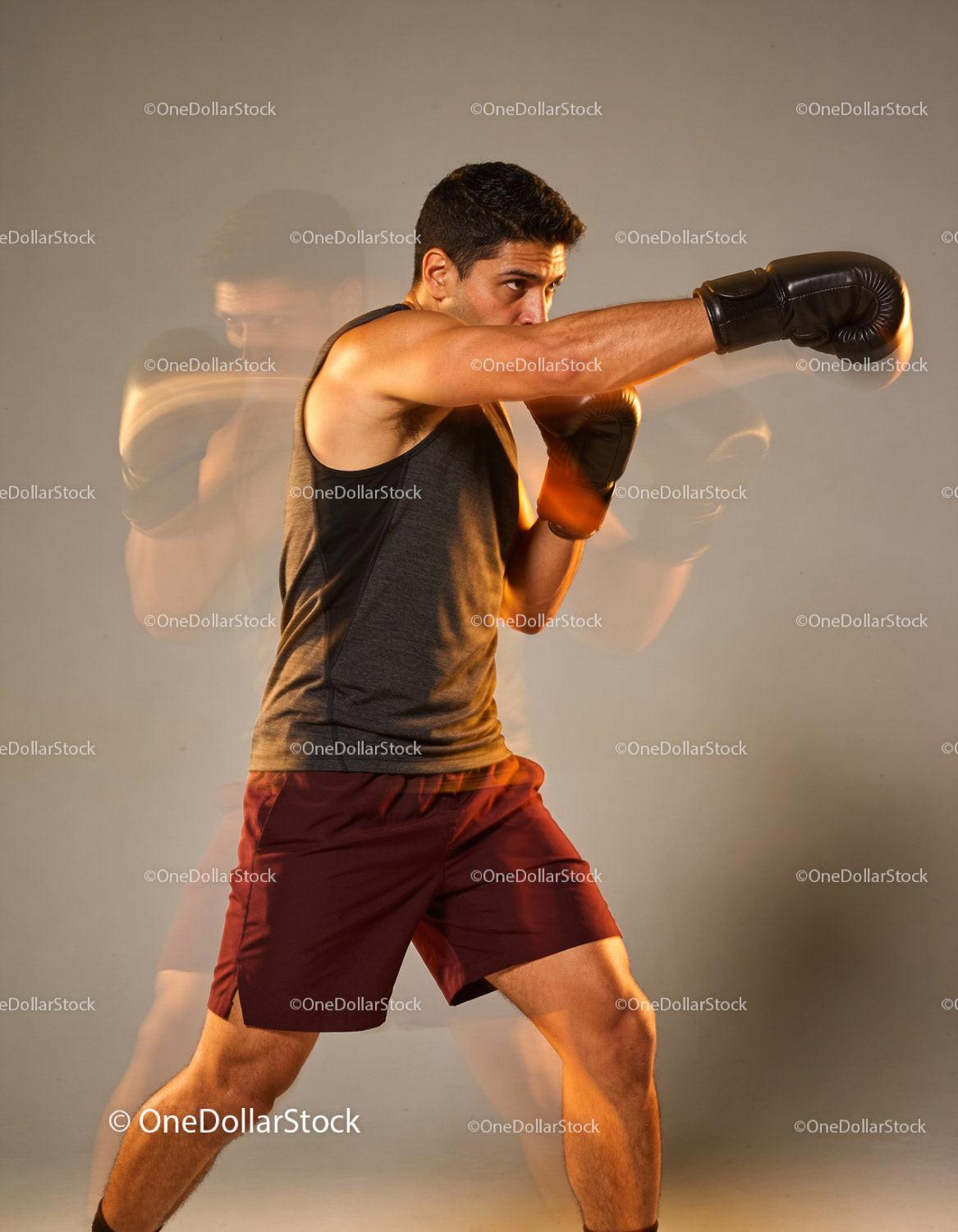Young male boxer practicing powerful punch with focus