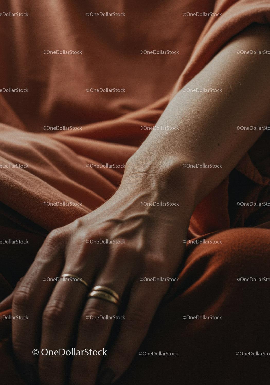 Close Up of Human Hand with Gold Rings and Skin Texture in Warm Tones