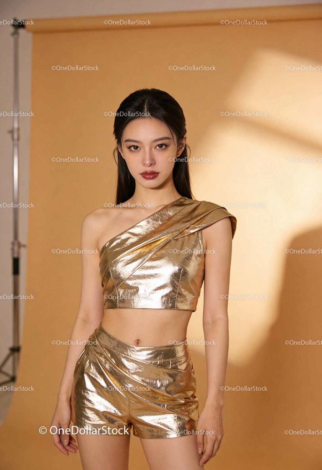 Elegant young woman in metallic gold fashion outfit