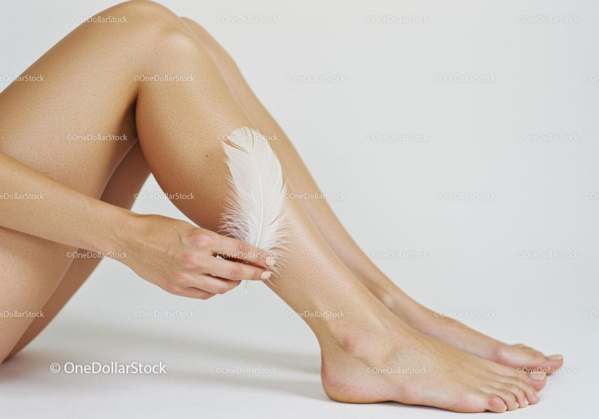 Elegant Female Legs with Feather for Skin Care Beauty Shot