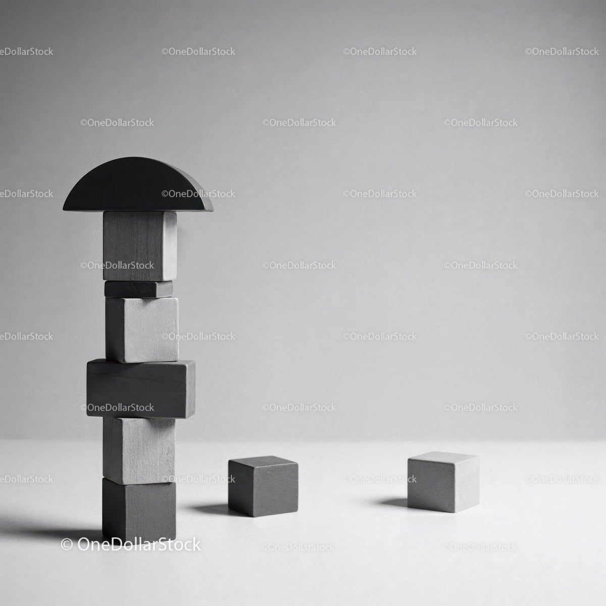 Stacked wooden geometric blocks with black half circle and separate cubes on neutral surface