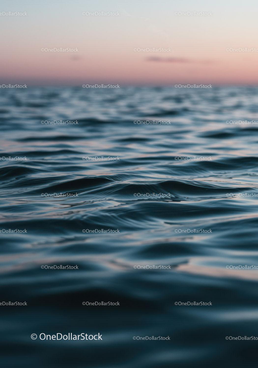 Calm Ocean Waves Against Sunset Sky with Water Ripples