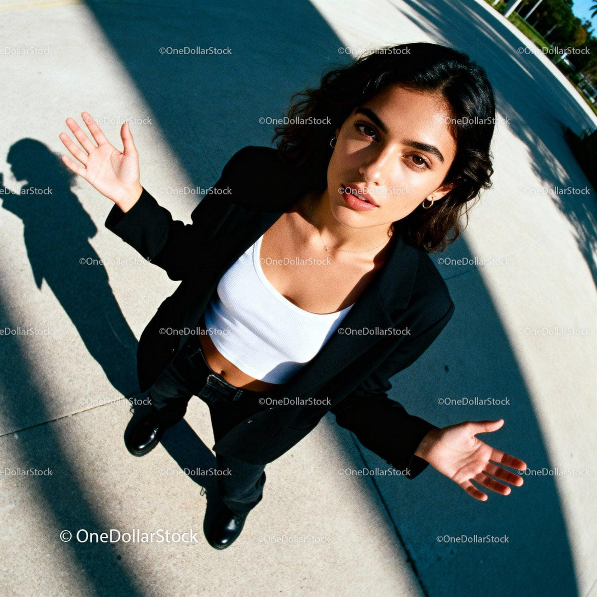 Confident young woman standing outdoors with open hands