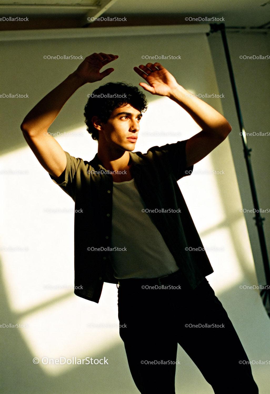 Young man posing with raised hands in warm sunlight