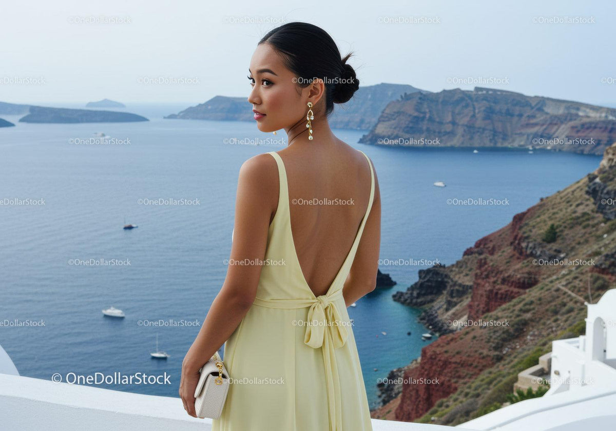 Elegant woman in yellow dress overlooking sea cliff
