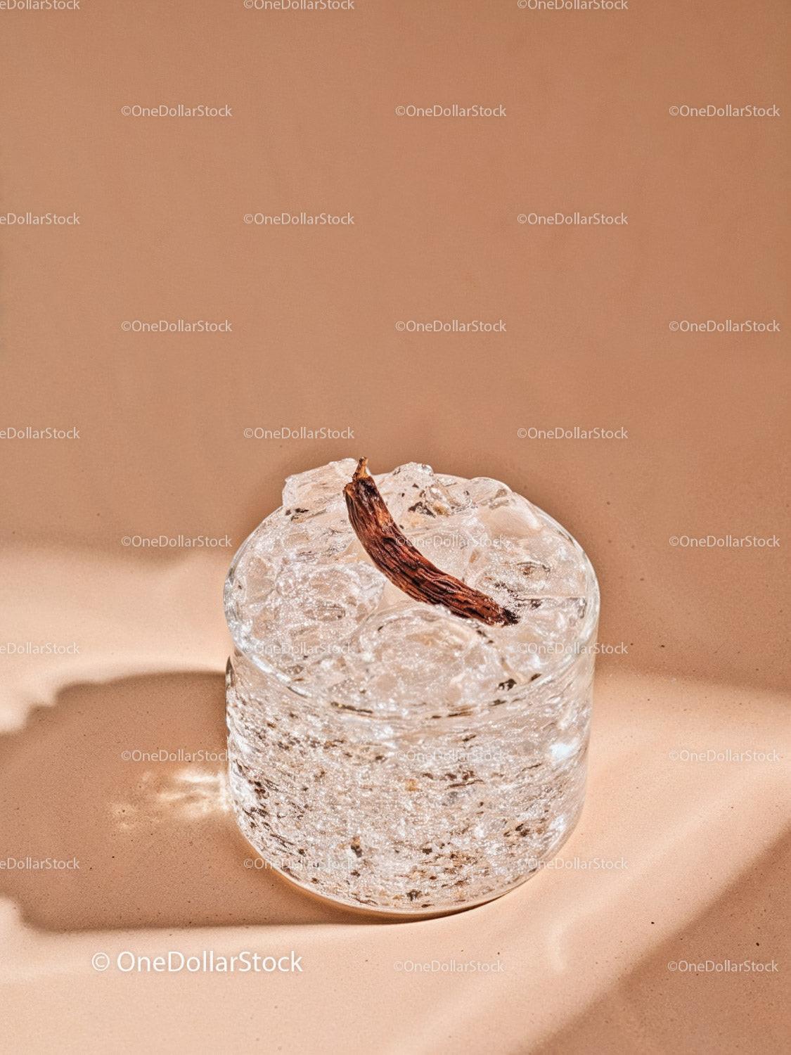Refreshing clear cocktail with dried vanilla pod garnish