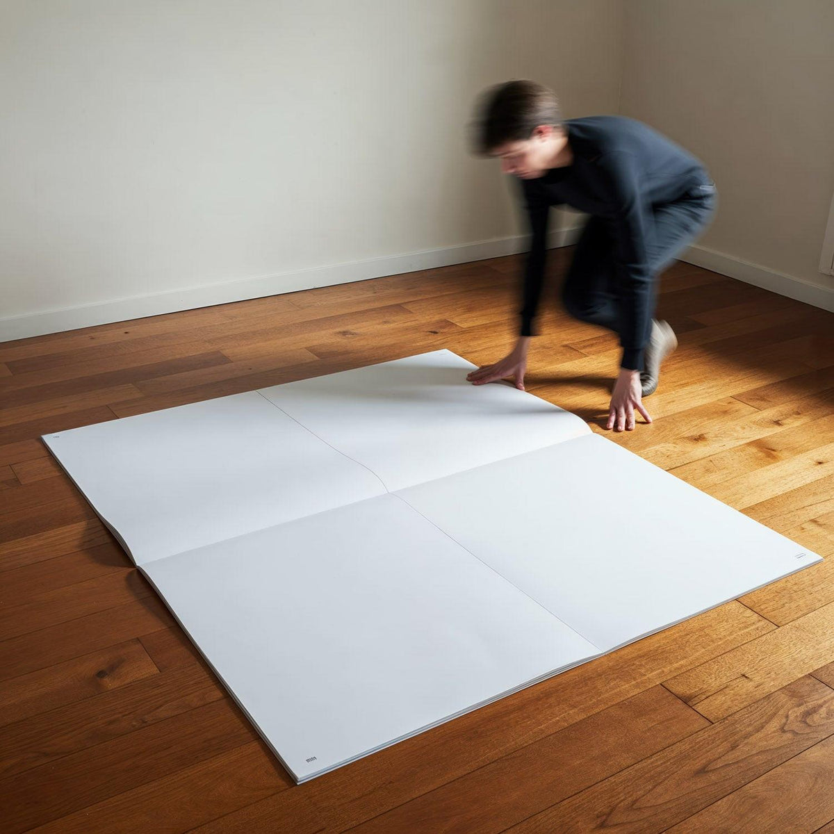 Person Unfolding Giant Blank Paper on Wooden Floor JPG Mockup Image preview