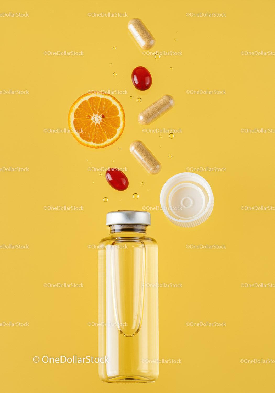 Supplements and fresh orange slice with liquid bottle