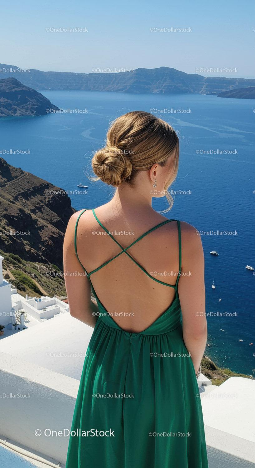 Woman in green dress overlooking blue sea and cliffs