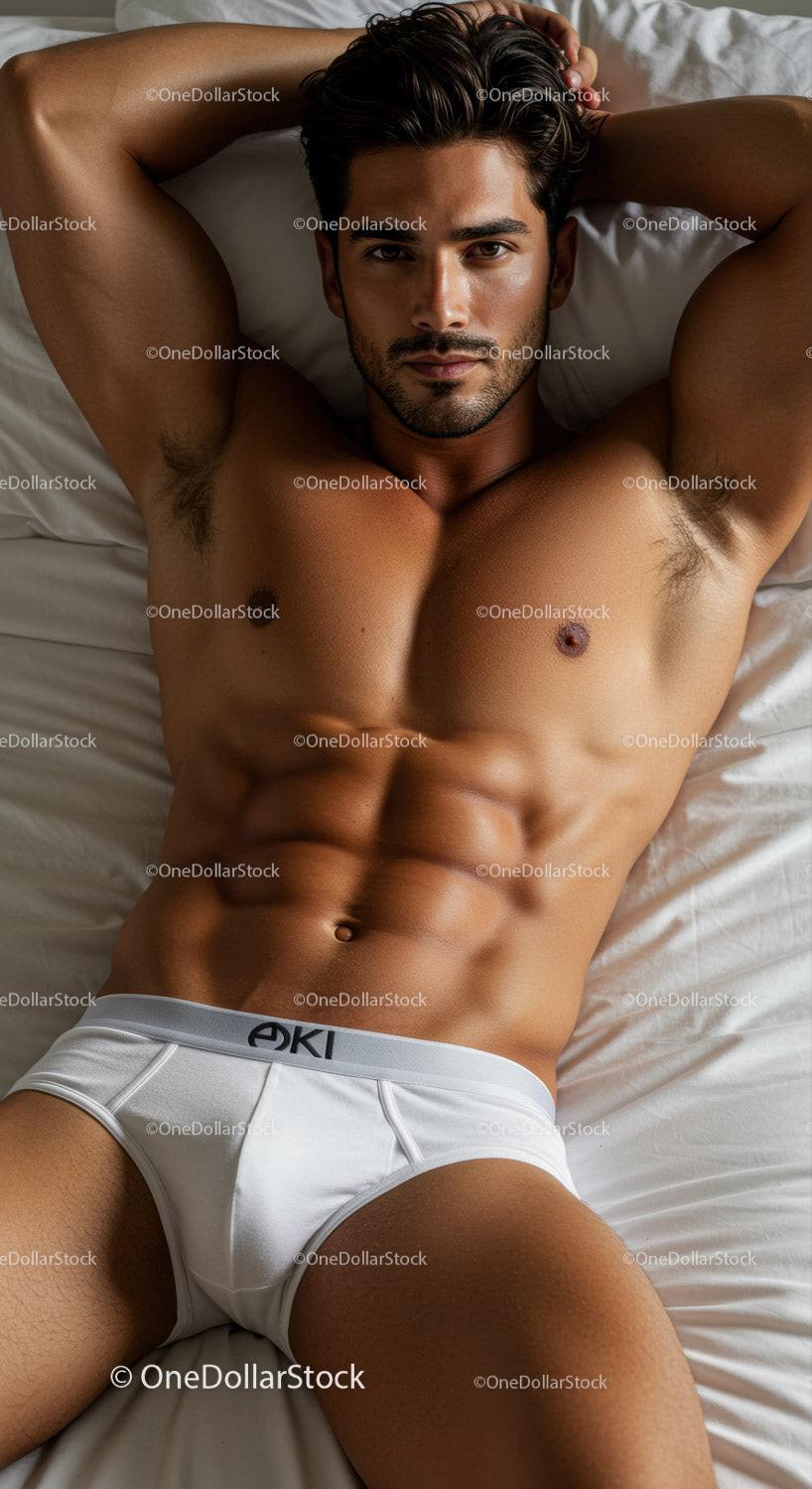 Fit young man relaxing on bed in white briefs